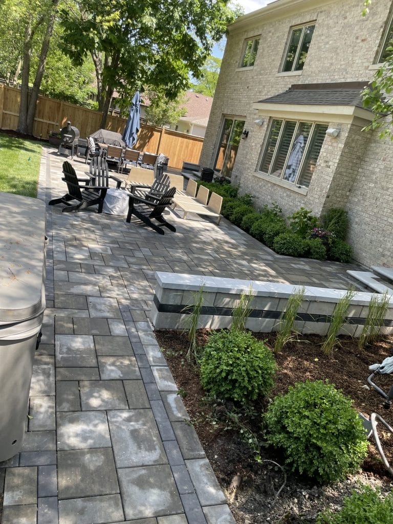 Outdoor patio area with stone pavers and seating by an Outdoor Contractor

