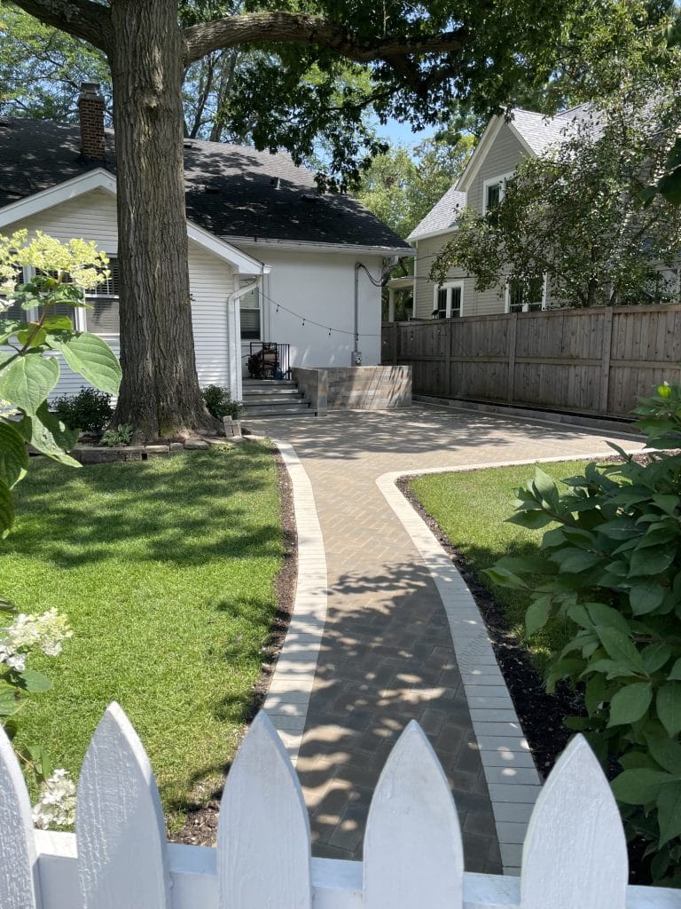Outdoor Contractor Completed Brick Walkway and Patio in Residential Backyard
